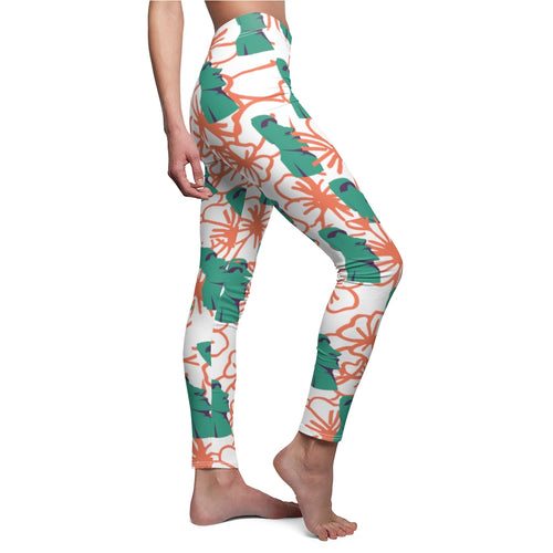 Tiki Flower Leggings with a white background.  Orange outlined hibiscus flowers and teal green  Easter Island statue heads in a repeating pattern.