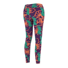 Load image into Gallery viewer, Tiki Flower Leggings with a dark purple background.  Orange outlined hibiscus flowers and teal green  Easter Island statue heads in a repeating pattern.
