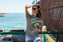 Load image into Gallery viewer, Sport your aloha with this perfectly tropical tee. Junior&#39;s short sleeve tee. Hibiscus, tikis, and coconuts! Hawaii shirt. Her go-to tee fits like a well-loved favorite, featuring a slim feminine fit. Additionally, it is comfortable with super soft cotton and quality print. 
